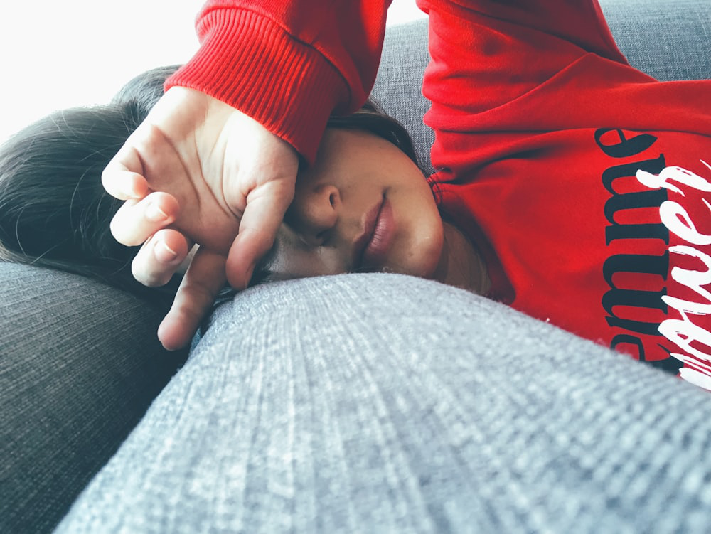 An Anemic Woman Covers the Top Half of Her Face With an Arm While Lying On Her Side