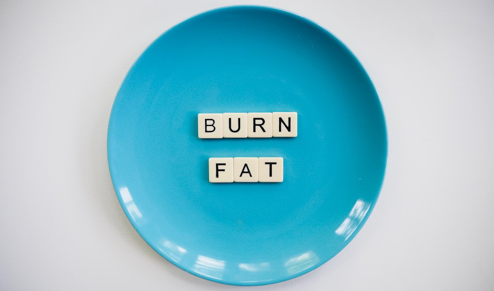 A Blue Dish Featuring Alphabet Bricks Spelling Out “Burn Fat”