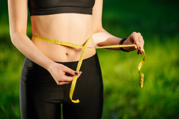 An image of a woman measuring her waist