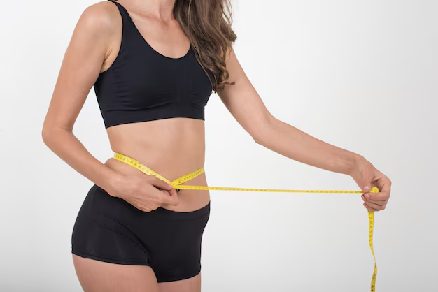 An image of a woman measuring her waist 