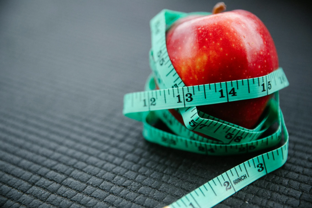 A measuring tape around an apple