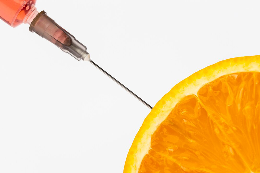 A closeup image shows a needle going into a slice of orange, representing Vitamin C injections