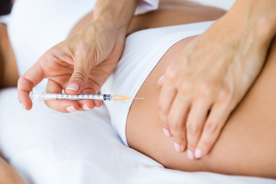 A person receives an injection in the thigh, similar to how Sermorelin injections are administered