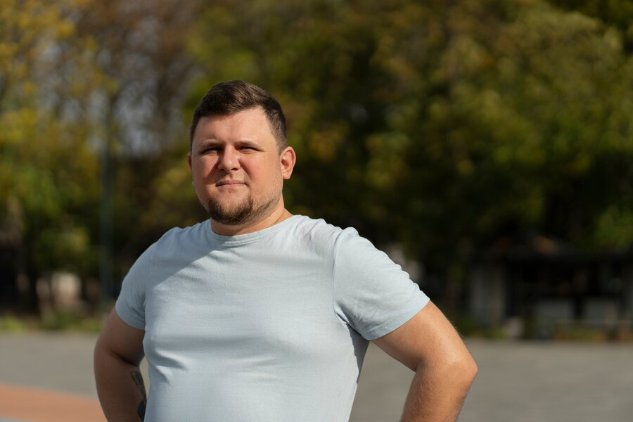 A man in a white t-shirt outdoors