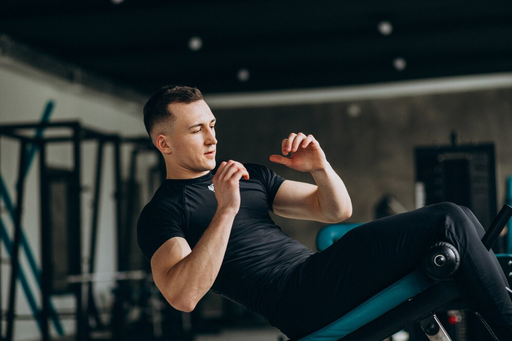 A man in black athletic wear on a machine at the gym