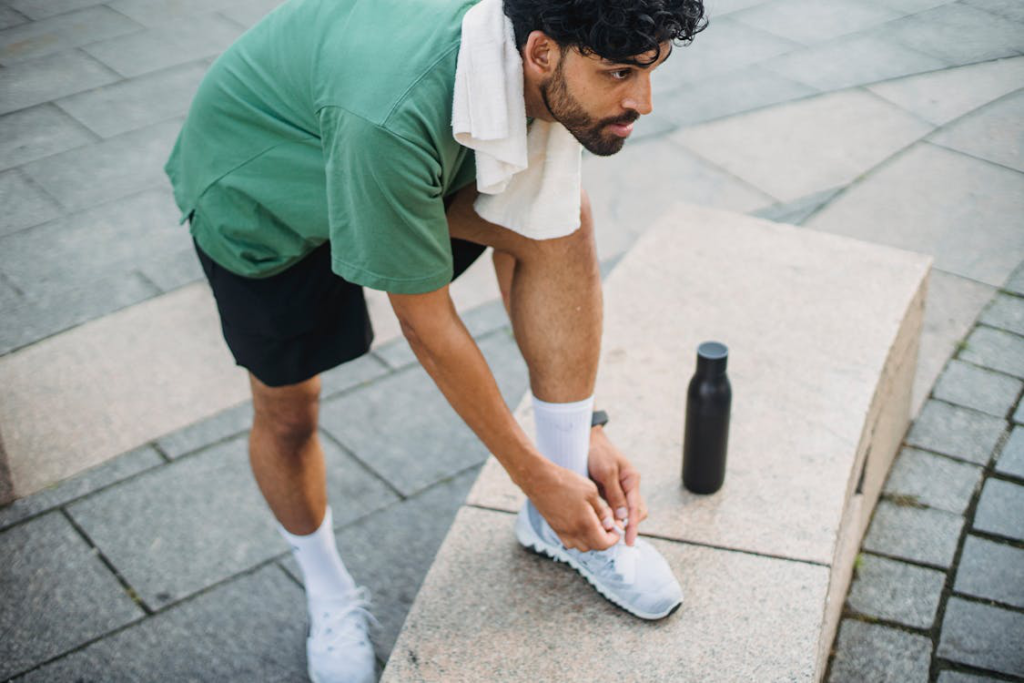 A man tying his shoes, ready for physical activity.