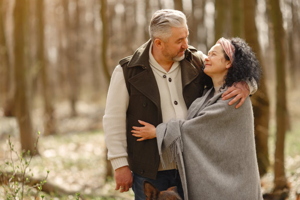 A cheerful middle-aged couple walking in the forest, enjoying a healthy and active lifestyle.