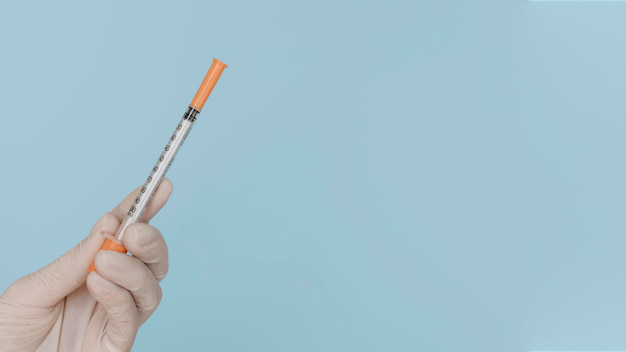 A close-up of a hand holding a weight loss injection syringe.