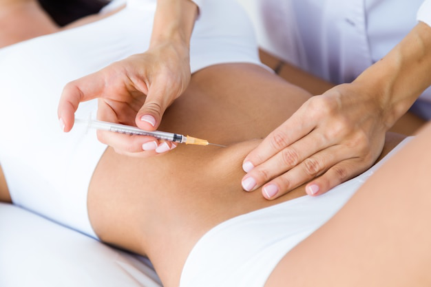 A healthcare professional administering an injectable therapy for weight management.