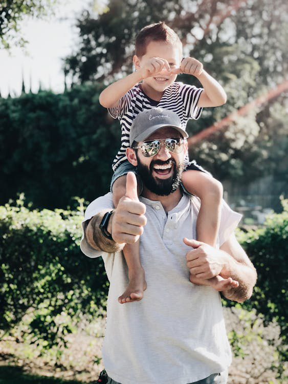 A joyful father giving his son a piggyback ride.