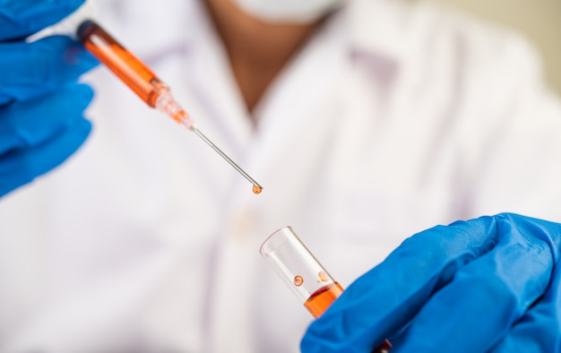 Close-up of a medical professional drawing an injection into a syringe.