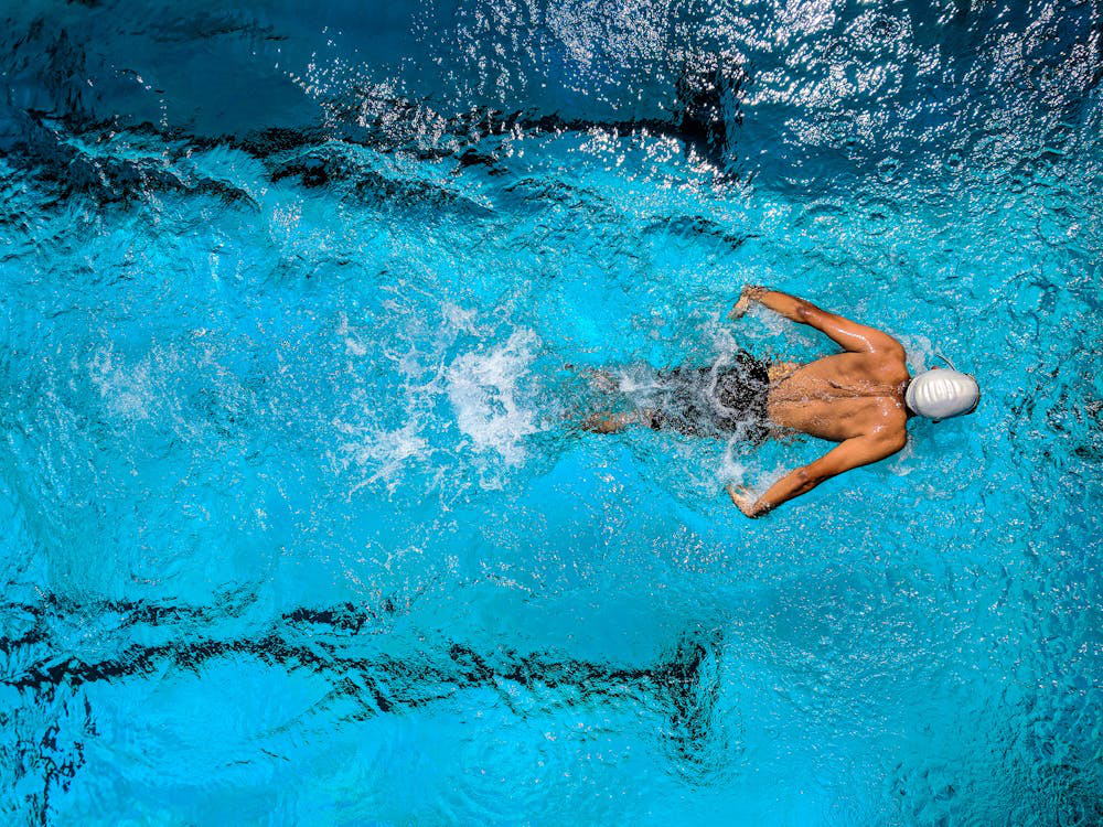 A competitive swimmer gliding through a pool, showcasing peak endurance.