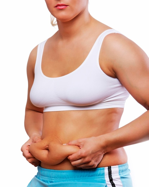 Woman pinching stubborn belly fat, showing weight loss frustration