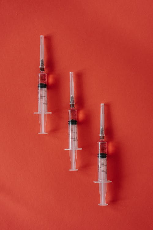 Three syringes on a red background