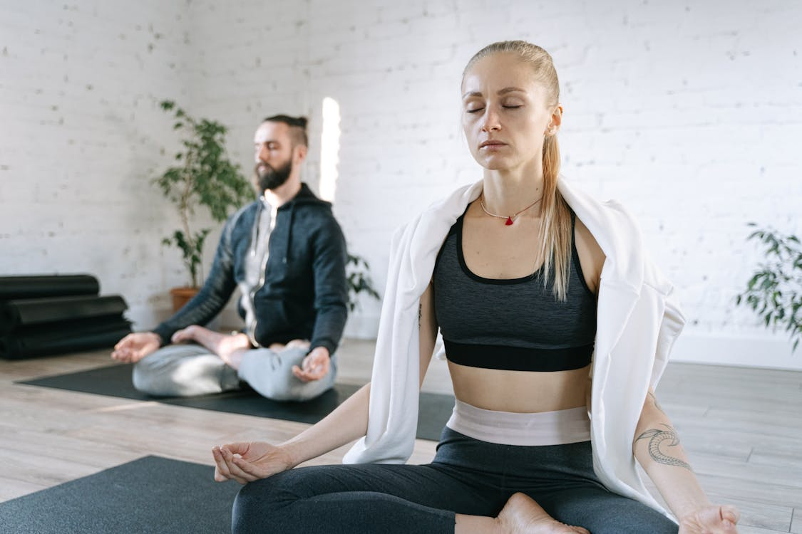  People meditating on yoga mats indoors