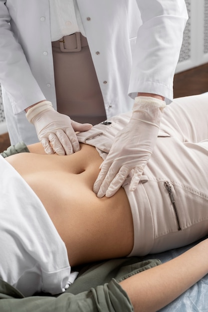 Healthcare provider examining the patient’s abdomen for gut-related concerns