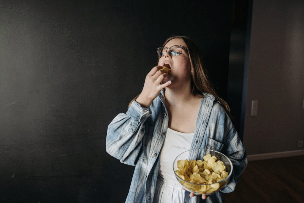 Woman in glasses eating chips from a bowl