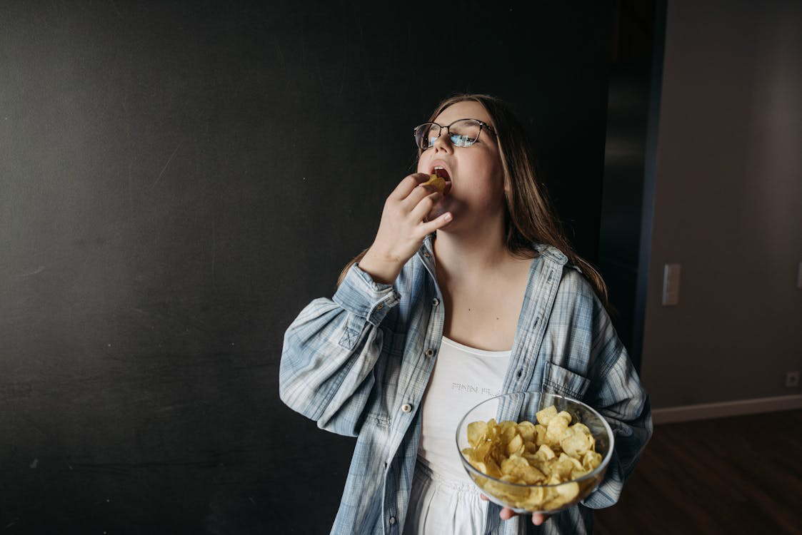 Woman in glasses eating chips from a bowl