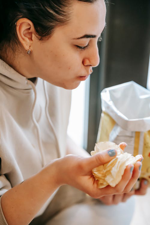 Woman holding a handful of chips while watching a screen