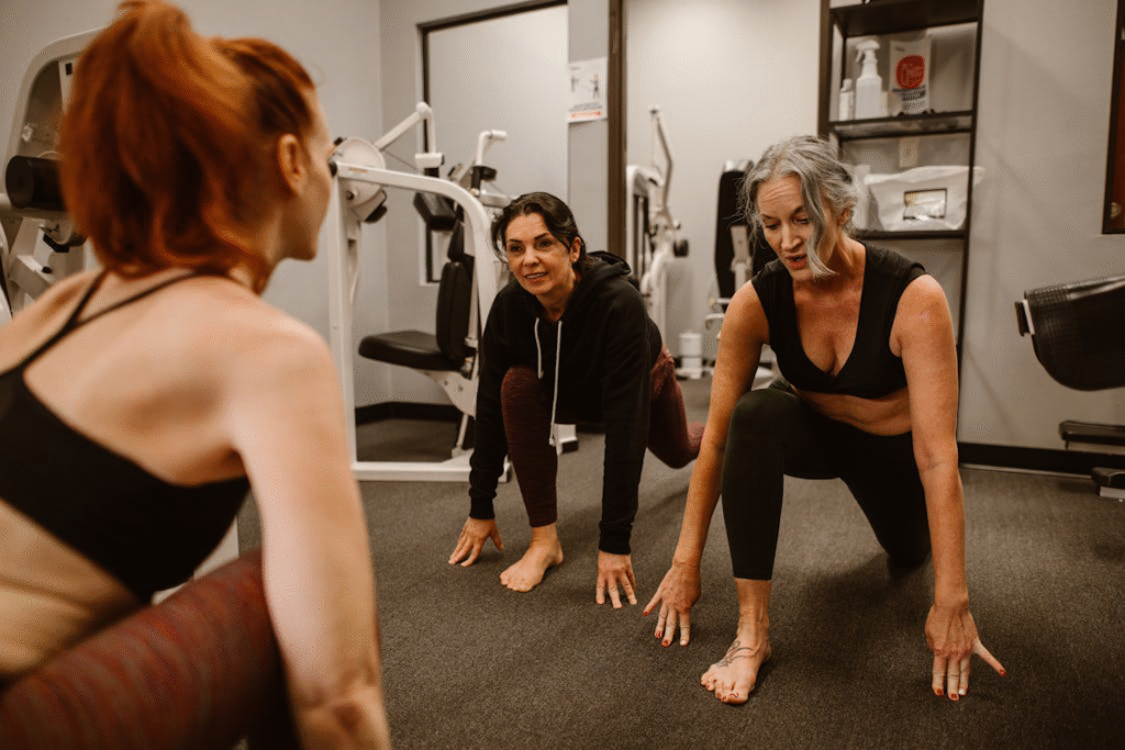 Two women working out with a personal trainer at the gym