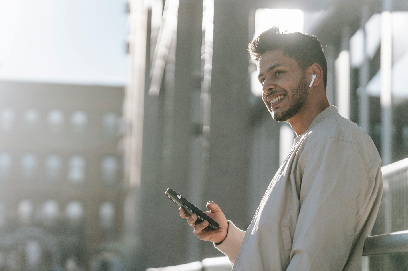 Confident, energized man smiling with earbuds outside after wellness treatment