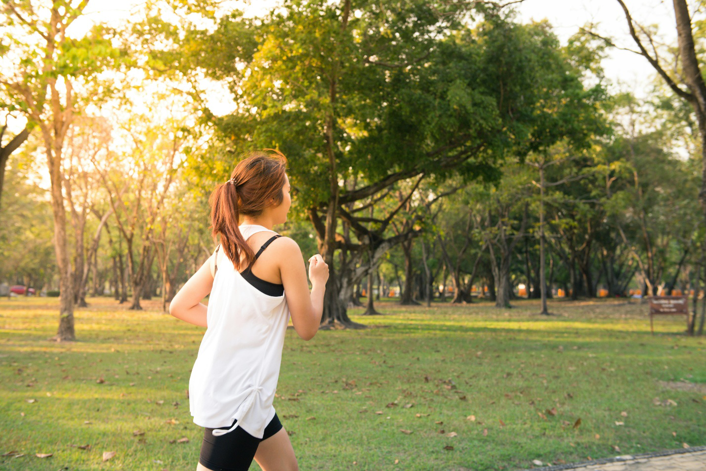 Woman jogging in a park after receiving vitamin injections in San Angelo to boost energy and wellness