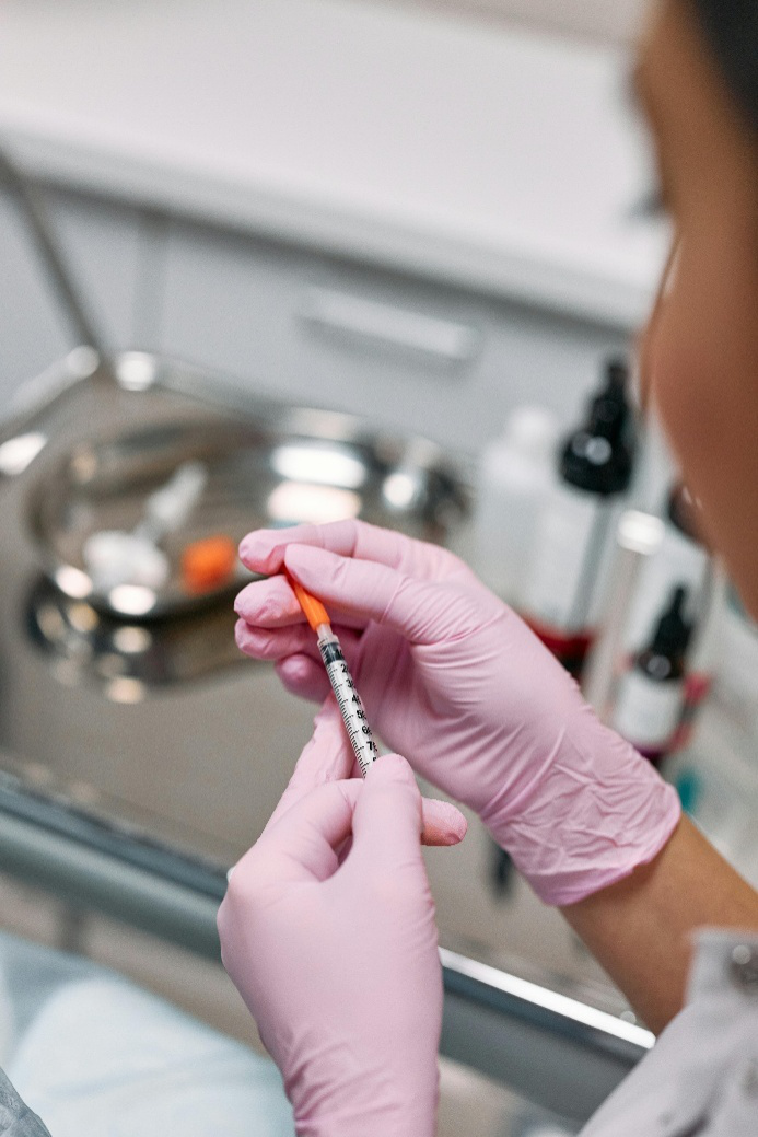 Healthcare provider holding a syringe for a vitamin injection at a medical clinic