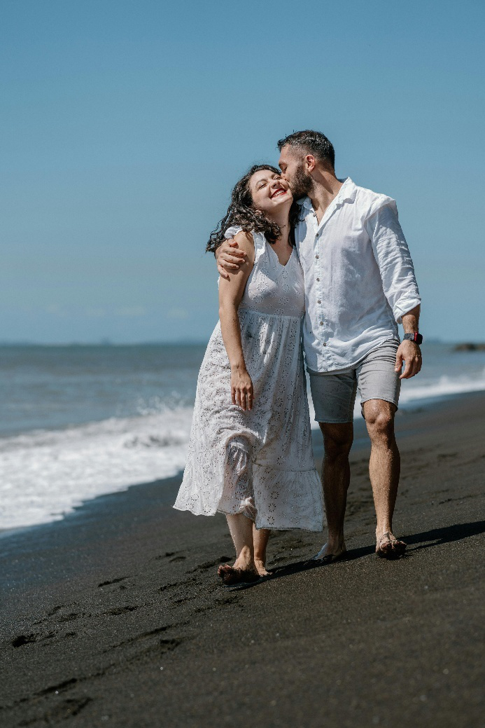 Happy couple walking on the beach, looking energized and youthful