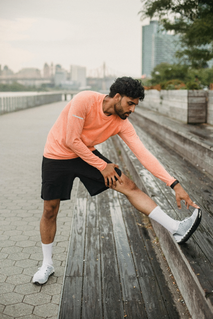 Athletic man stretching outdoors in workout gear, showing energy and focus