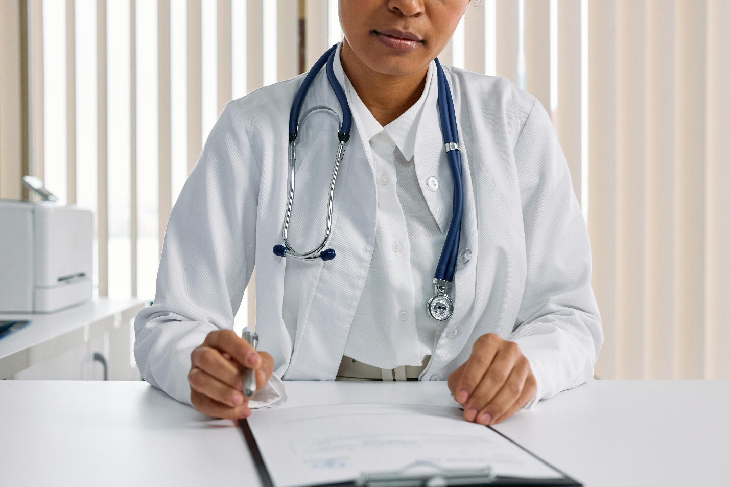 Medical professional reviewing notes with a clipboard and stethoscope