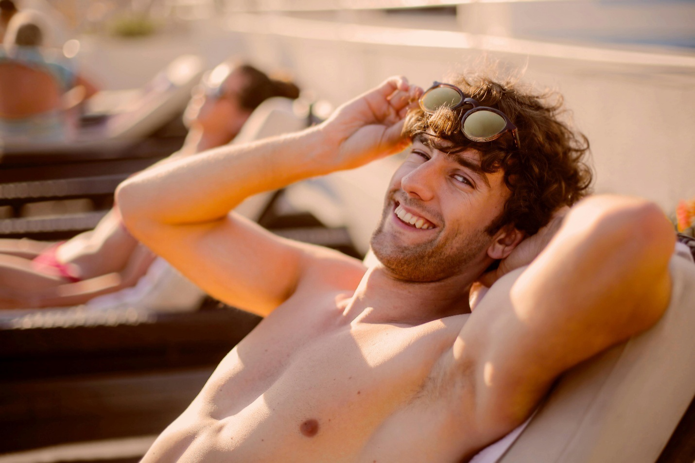 Man smiling and relaxed on a lounge chair post-recovery