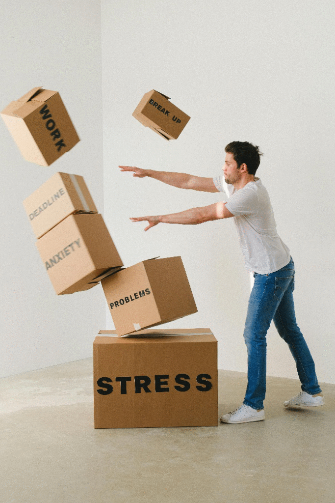 Man overwhelmed by stress, boxes labeled anxiety, work, breakup