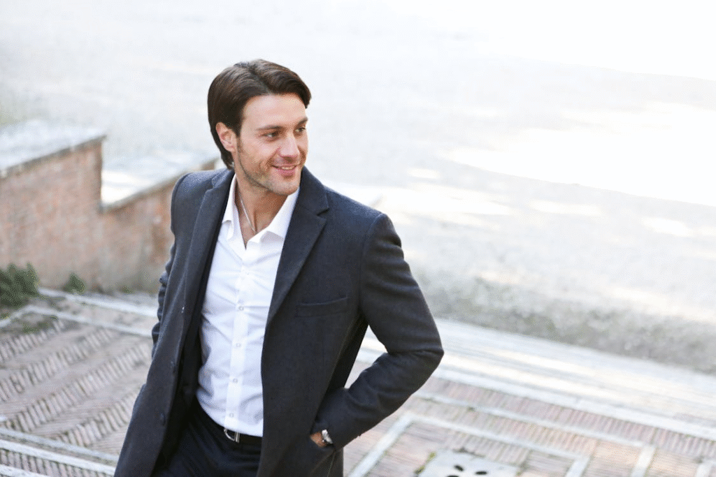 An image of a man wearing a suit while standing outdoors 