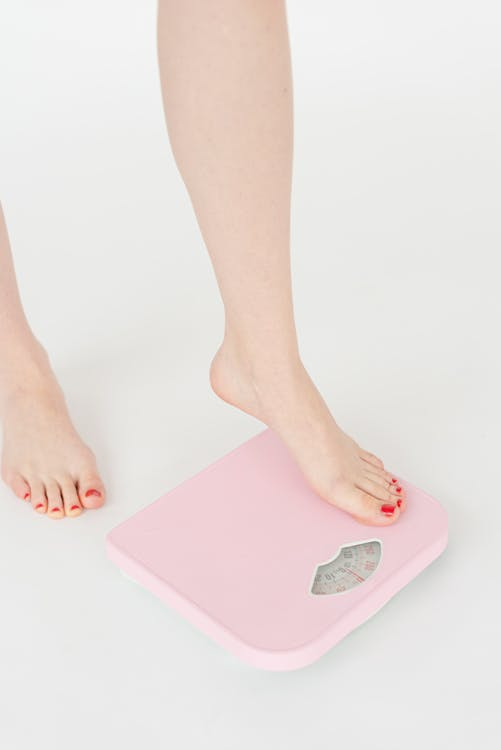 An image of a woman stepping on a weight machine    