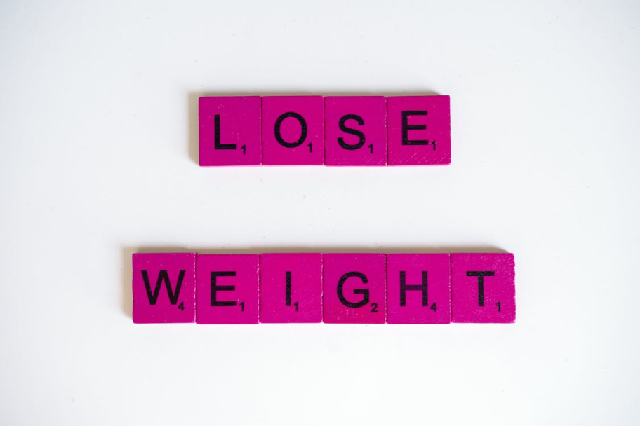 An image of tiles arranged on a white surface, reading “lose weight”