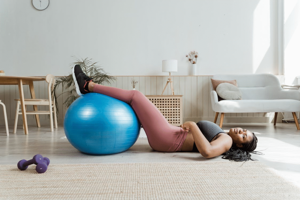 a woman resting on the floor with her legs on a gym ball.