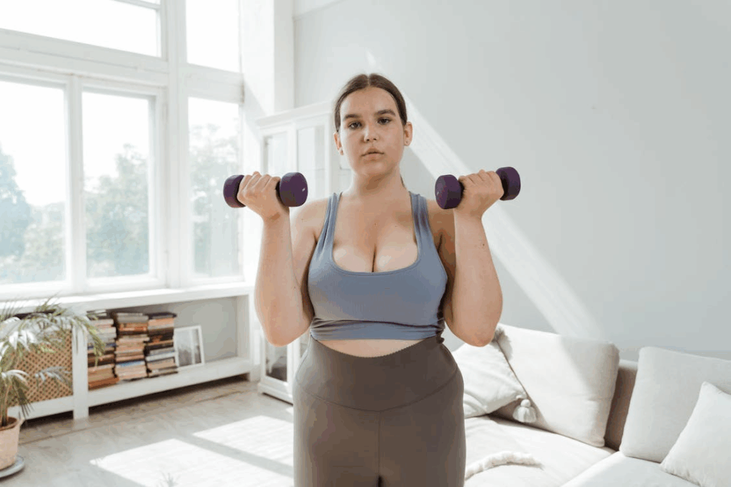An image of a woman working out using dumbbells 