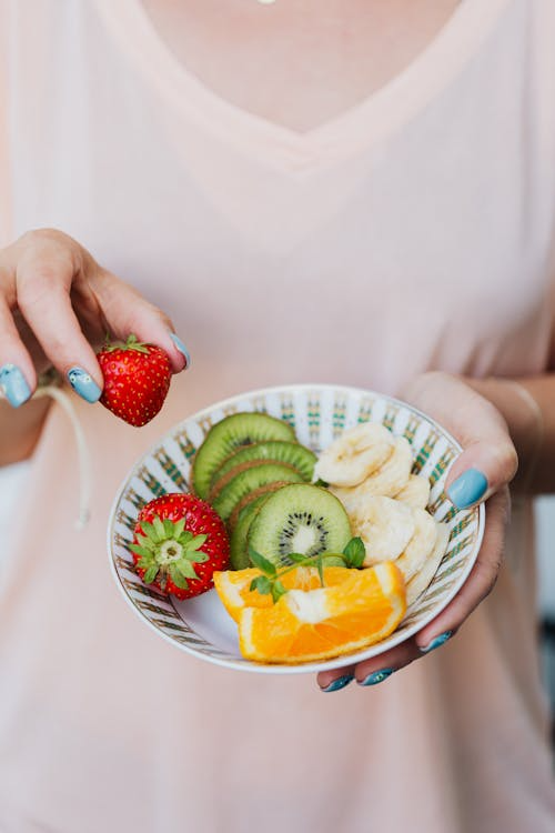 An image of a person holding a fruit bowl  