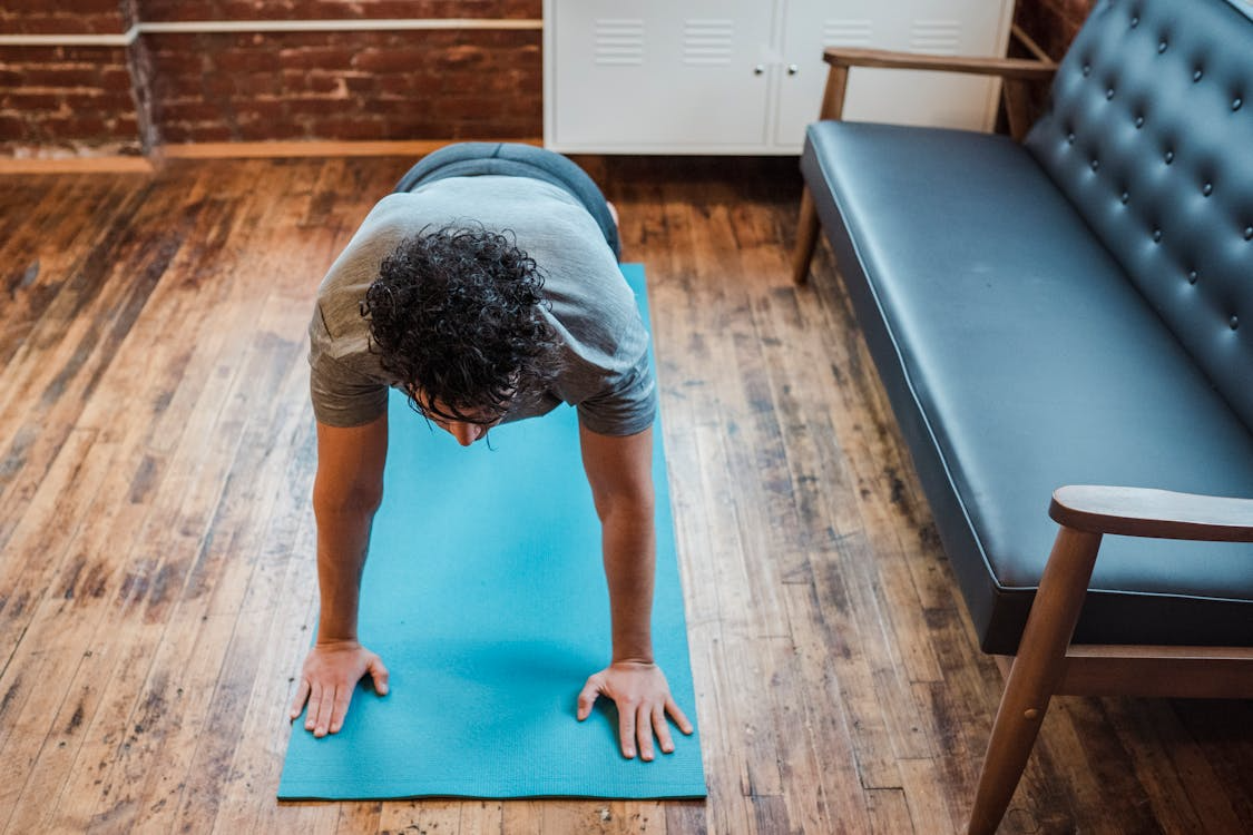 An image of a man working out on a blue mat 