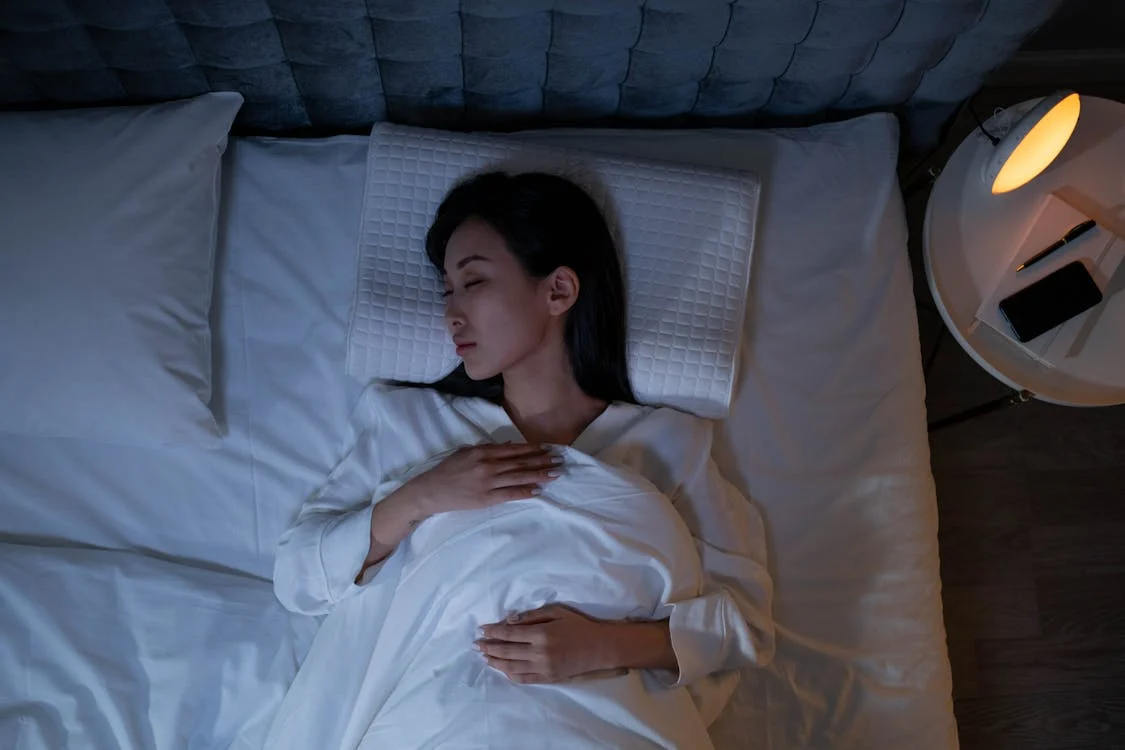 An image of a woman sleeping in bed