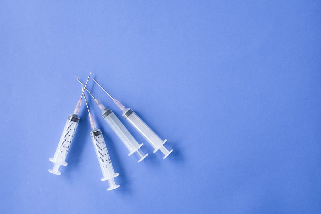 An image of syringes on a blue surface
