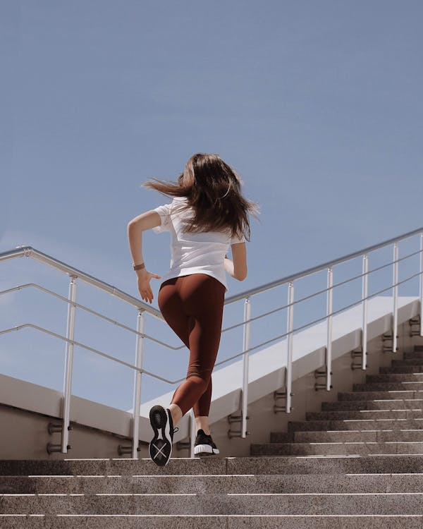 An image of a woman running up a flight of stairs