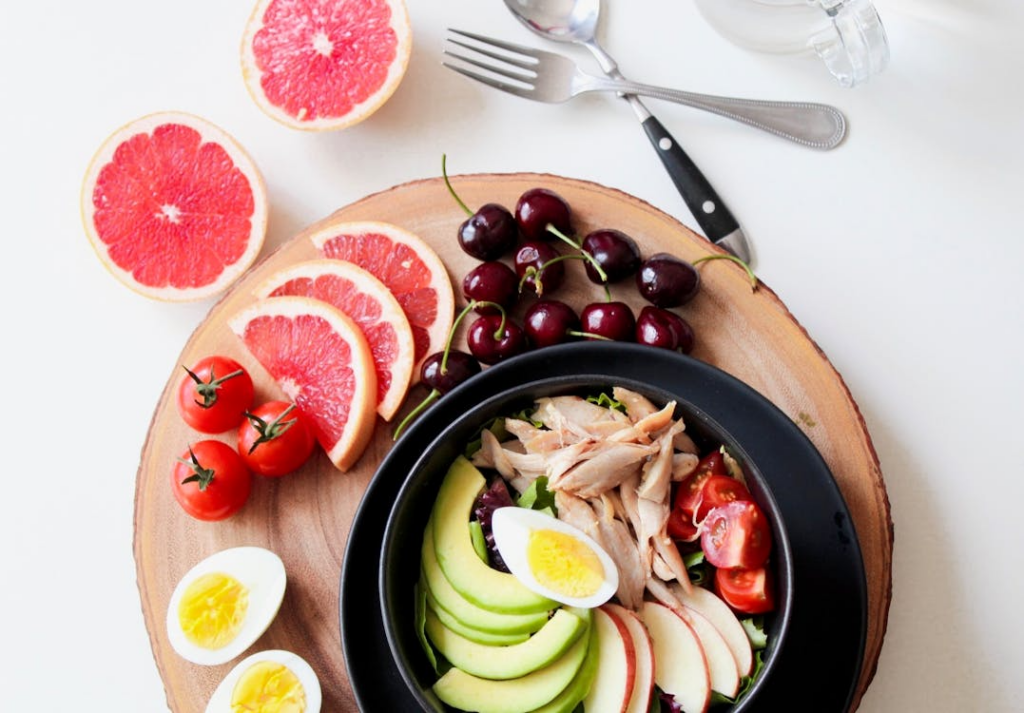 An image of a bowl of vegetables and sliced fruit