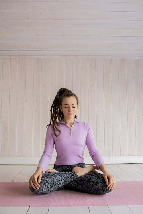 An image of a woman sitting on a yoga mat