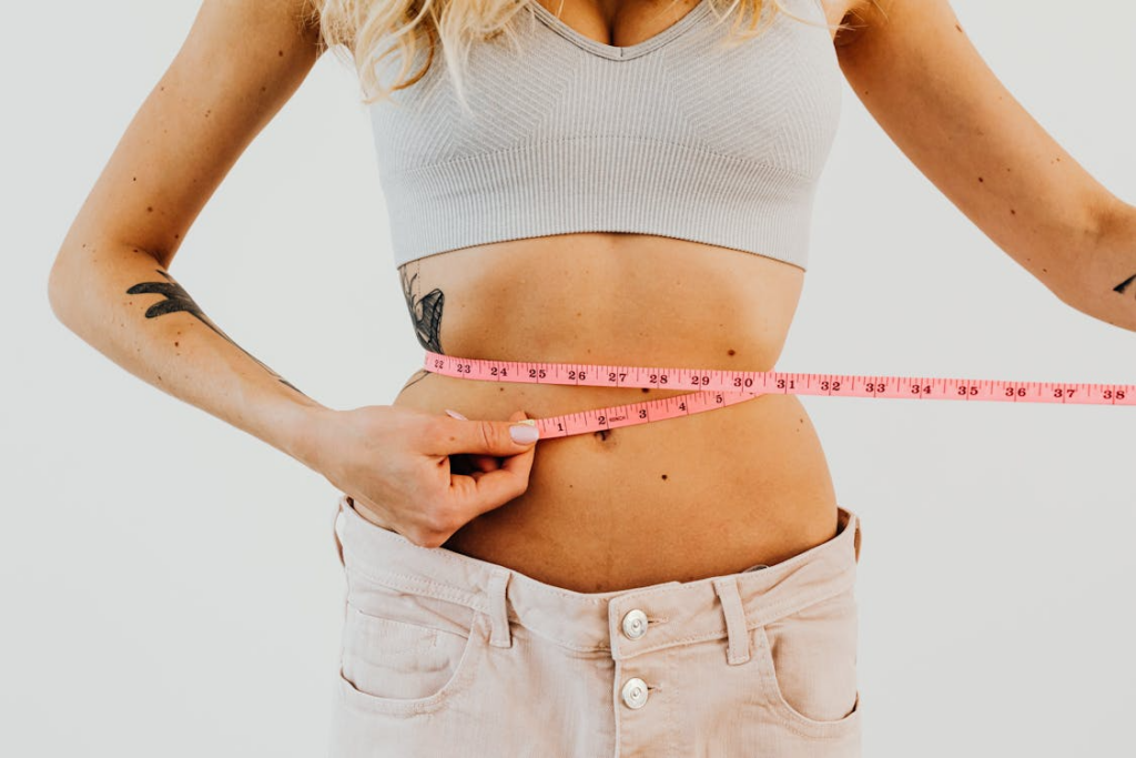 A woman measuring her waist with a tape