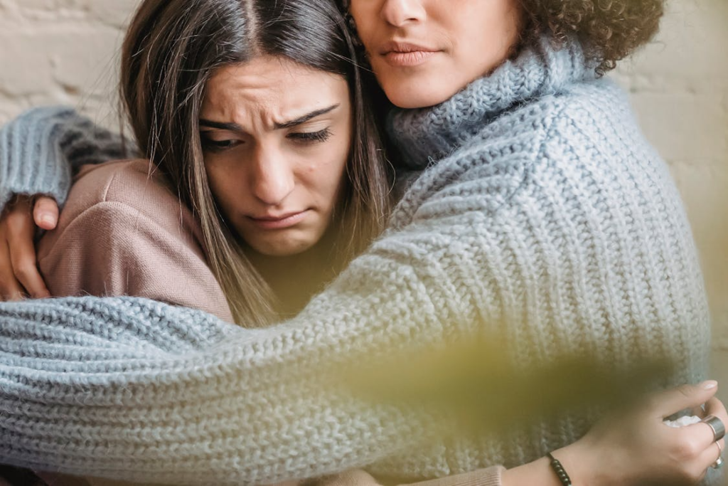 Woman hugging a friend who appears upset