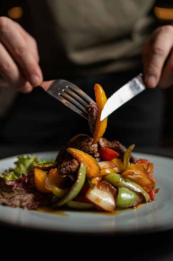 Adult eating a balanced meal with fresh vegetables and lean protein