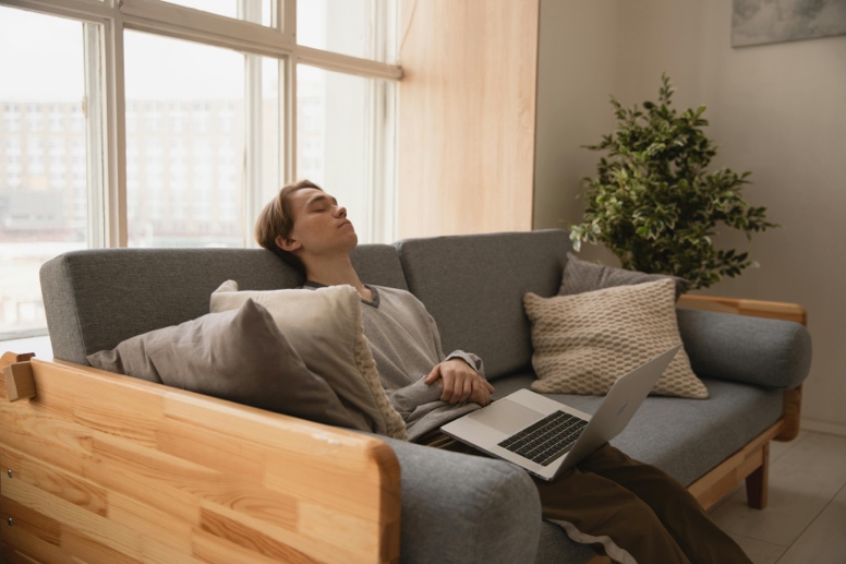 Adult resting comfortably on a sofa in a calm home environment