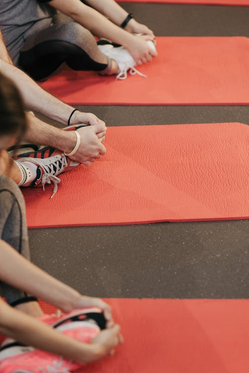 An image of people warming up while sitting on yoga mats