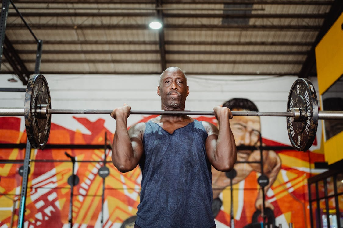 a man lifting weights in a gym with focused expression